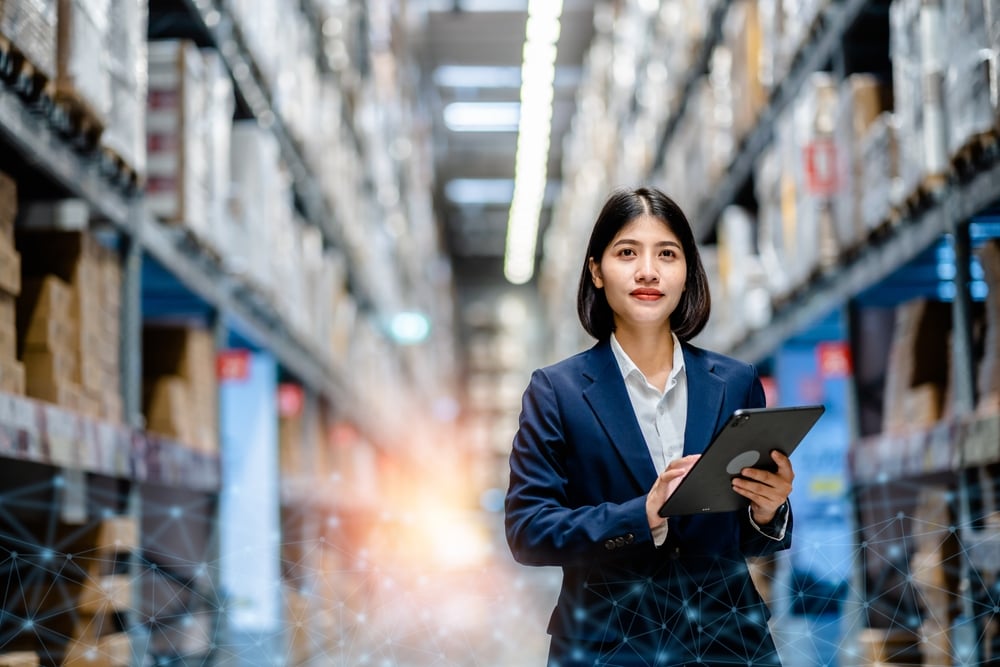 Woman with tablet in warehouse aisle